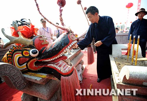 6月2日，祭司正在赛前祭龙头。 当日，“我们的节日·端午节”主题文化活动暨第三届中国汨罗江国际龙舟邀请赛在湖南汨罗市举行。来自澳大利亚、荷兰以及中国各地的十几支龙舟队在汨罗江参加角逐。汨罗是中国古代伟大诗人屈原晚年生活、创作和投江殉国之地。 新华社记者 李尕 摄 