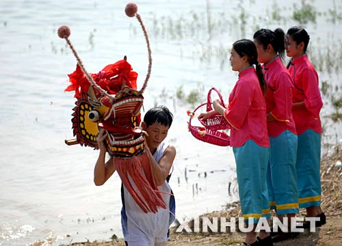 6月2日，一名龙舟队员正在汨罗江边祭龙头。 当日，“我们的节日·端午节”主题文化活动暨第三届中国汨罗江国际龙舟邀请赛在湖南汨罗市举行。来自澳大利亚、荷兰以及中国各地的十几支龙舟队在汨罗江参加角逐。汨罗是中国古代伟大诗人屈原晚年生活、创作和投江殉国之地。 新华社记者 李尕 摄 