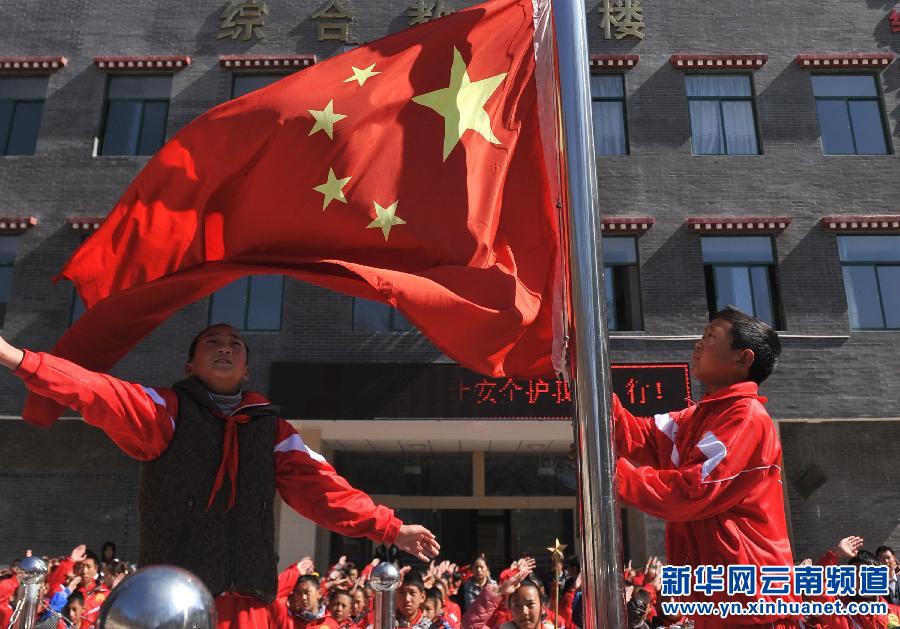 3月17日，云南省迪庆藏族自治州德钦县第一小学学生在教学楼前参加升旗仪式。新华社 蔺以光 摄